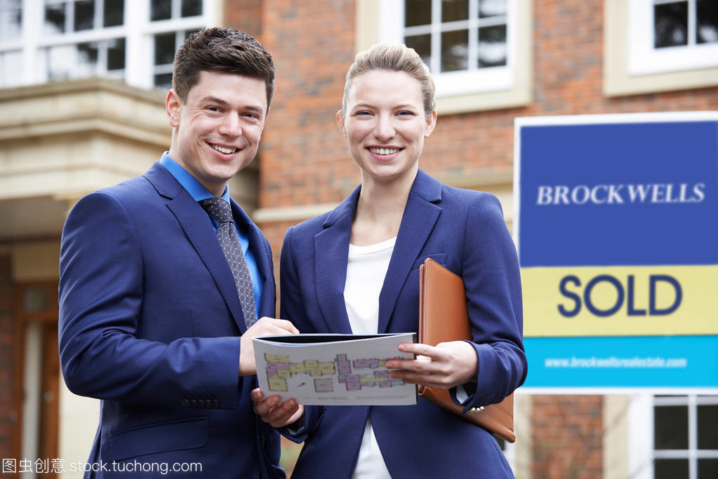 站在 Residentia 外的男、女房地產經紀人肖像