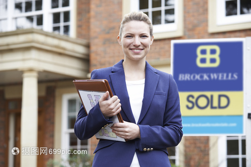 站住宅物業外的女房地產經紀人的肖像